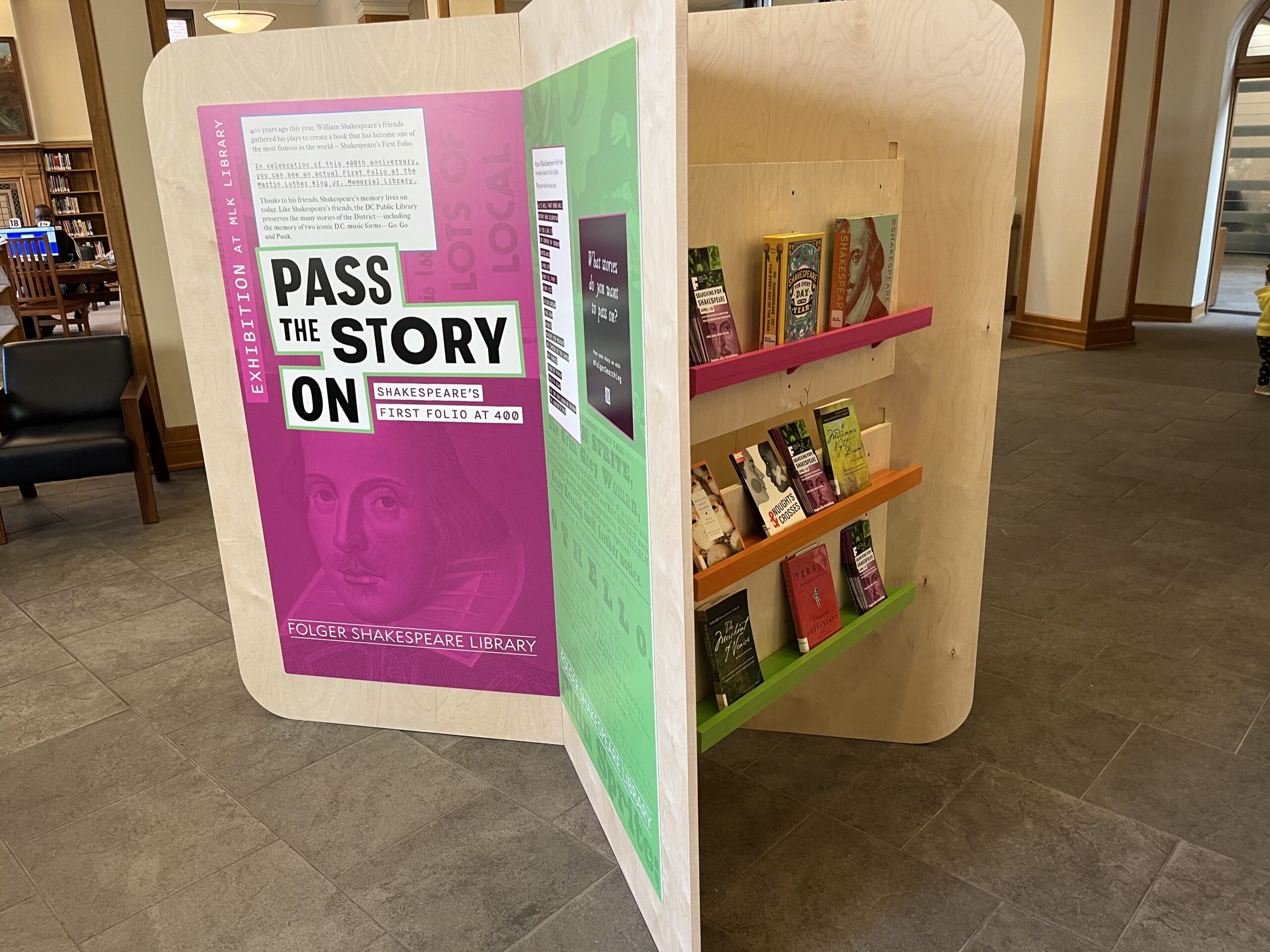 Kiosk including books and a title panel for an exhibition called "Pass the Story On."
