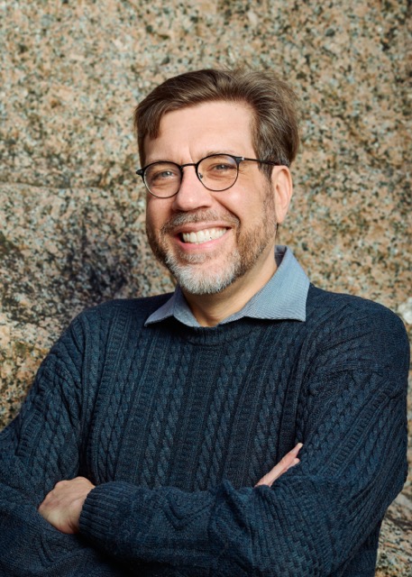 A man leaning against a granite monument.