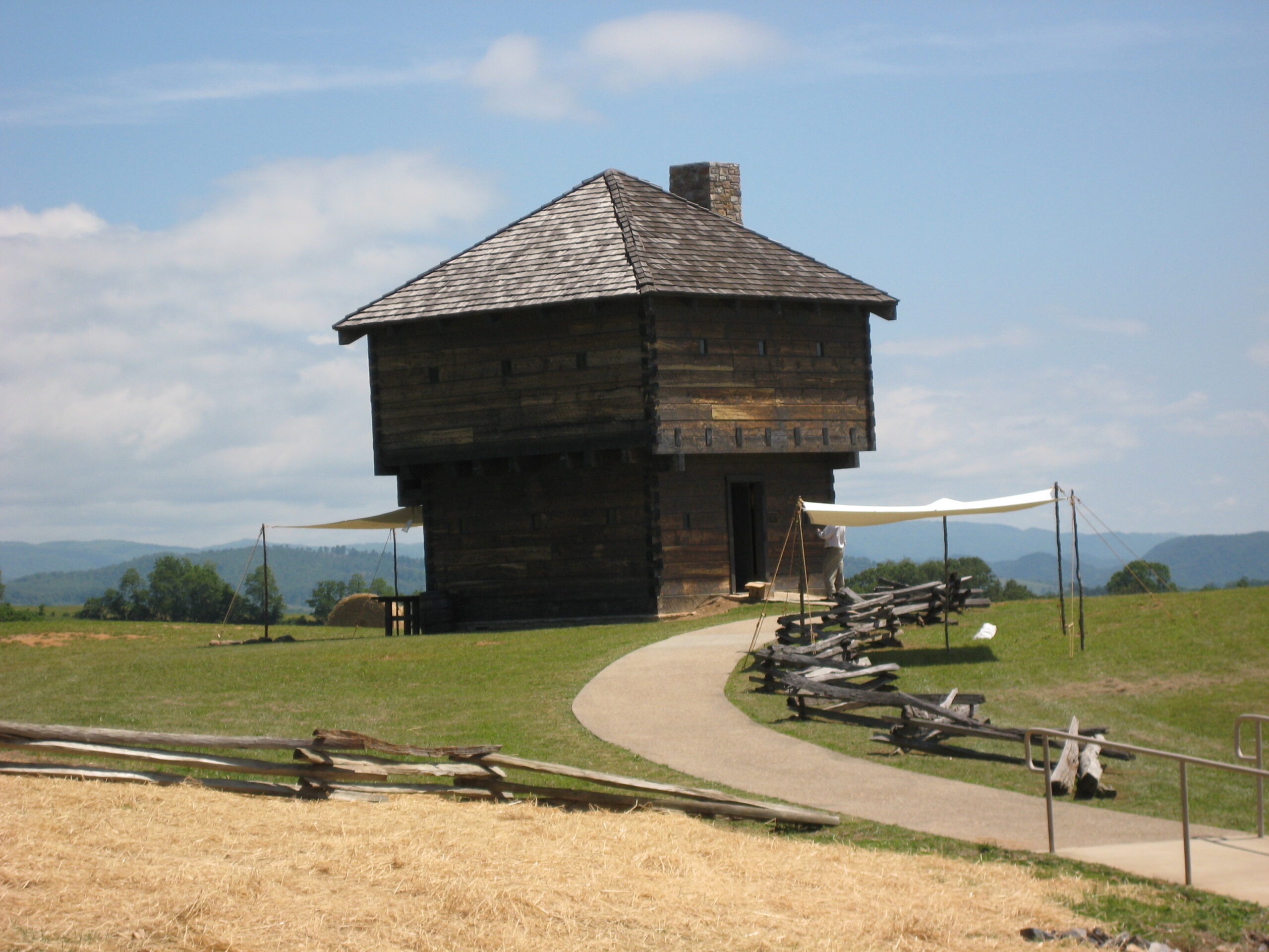 A log cabin with two levels, the top level slightly larger than the bottom.