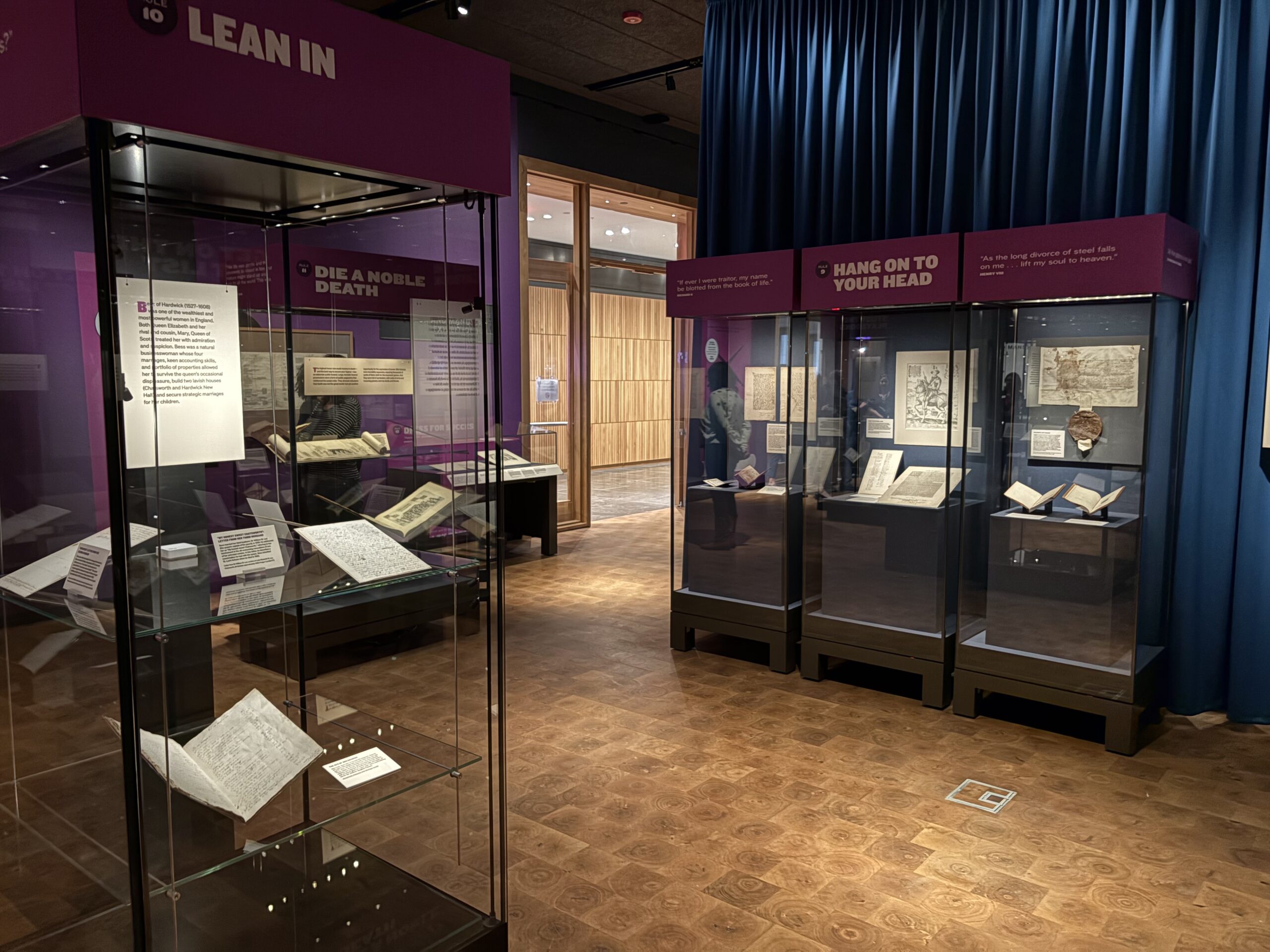 An exhibition gallery including cases with books and documents, along with title panels.
